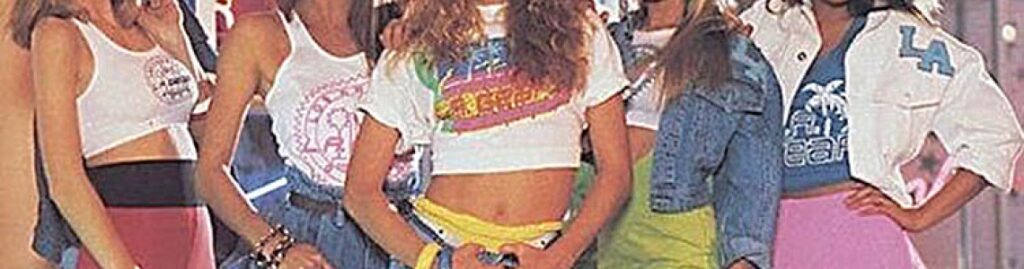 Groupe de jeunes femmes vêtues de crop tops imprimés, jupes fluo, vestes en jean et accessoires flashy, incarnant le style streetwear californien typique des années 80 dans une ambiance pop et décontractée