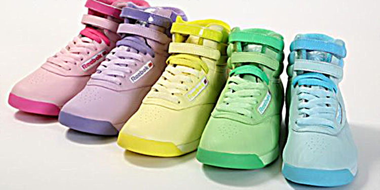 Collection de baskets montantes Reebok pour femme dans des tons pastel rose, violet, jaune, vert et bleu, typiques de la mode sportive et colorée des années 80.