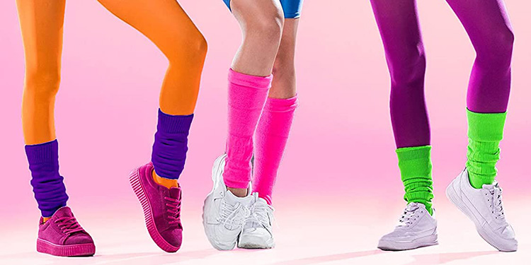 Trois silhouettes en tenues de sport des années 80 avec collants fluo orange, bleu et violet, jambières néon assorties et baskets rétro sur fond rose, illustrant la mode fitness fun et énergique de l’époque.