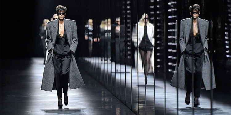 Défilé mode inspiré des années 80 – Manteau oversize, tailleur noir structuré et lunettes de soleil sur podium moderne